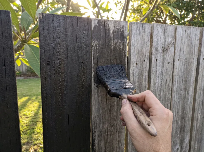 Weathered timber with paint lifting beside a freshly coated section